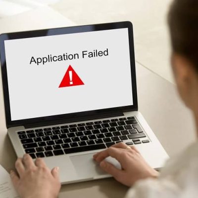 Girl,Looking,At,Laptop,With,Application,Failed,Error,On,Screen.